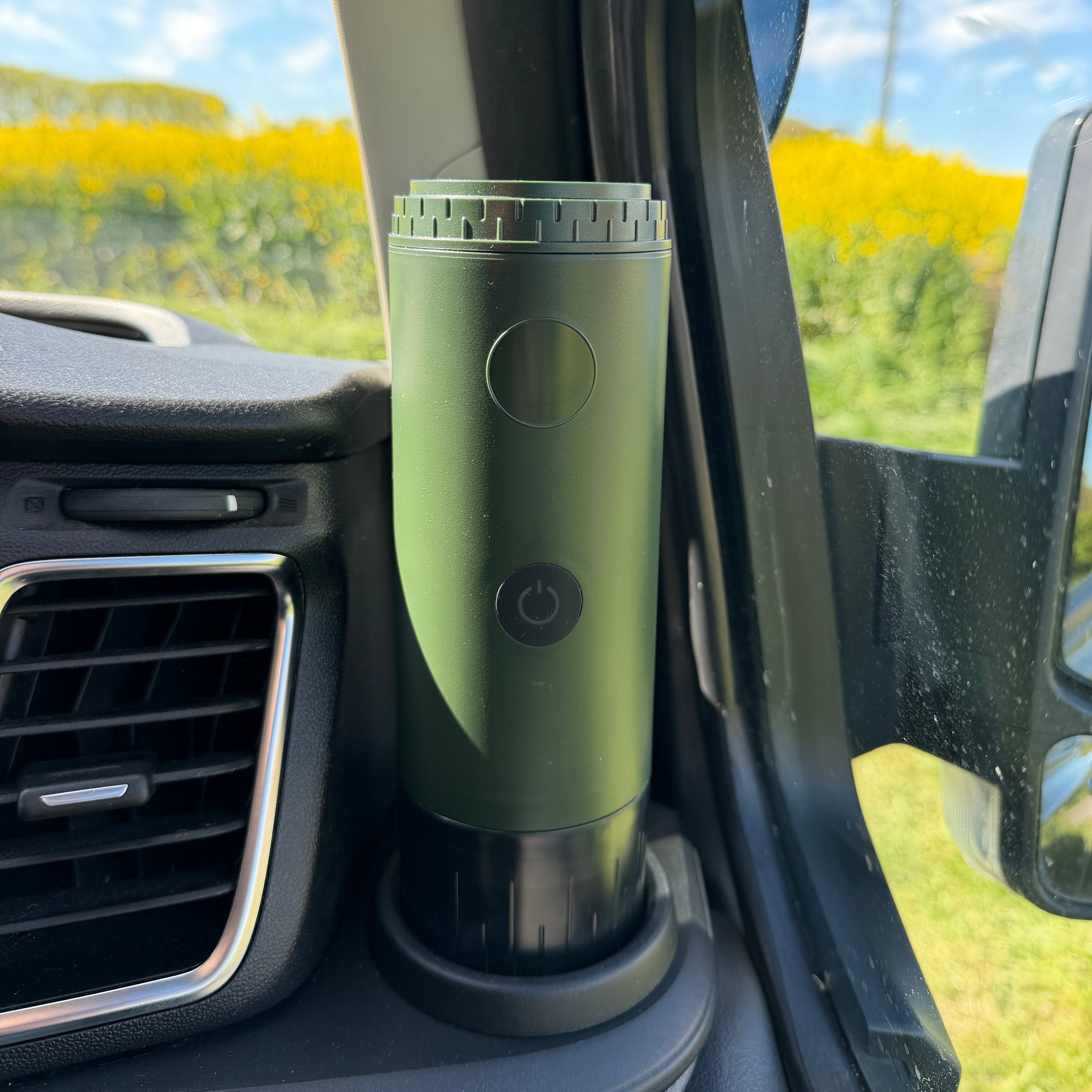 Green portable espresso maker in a car cup holder