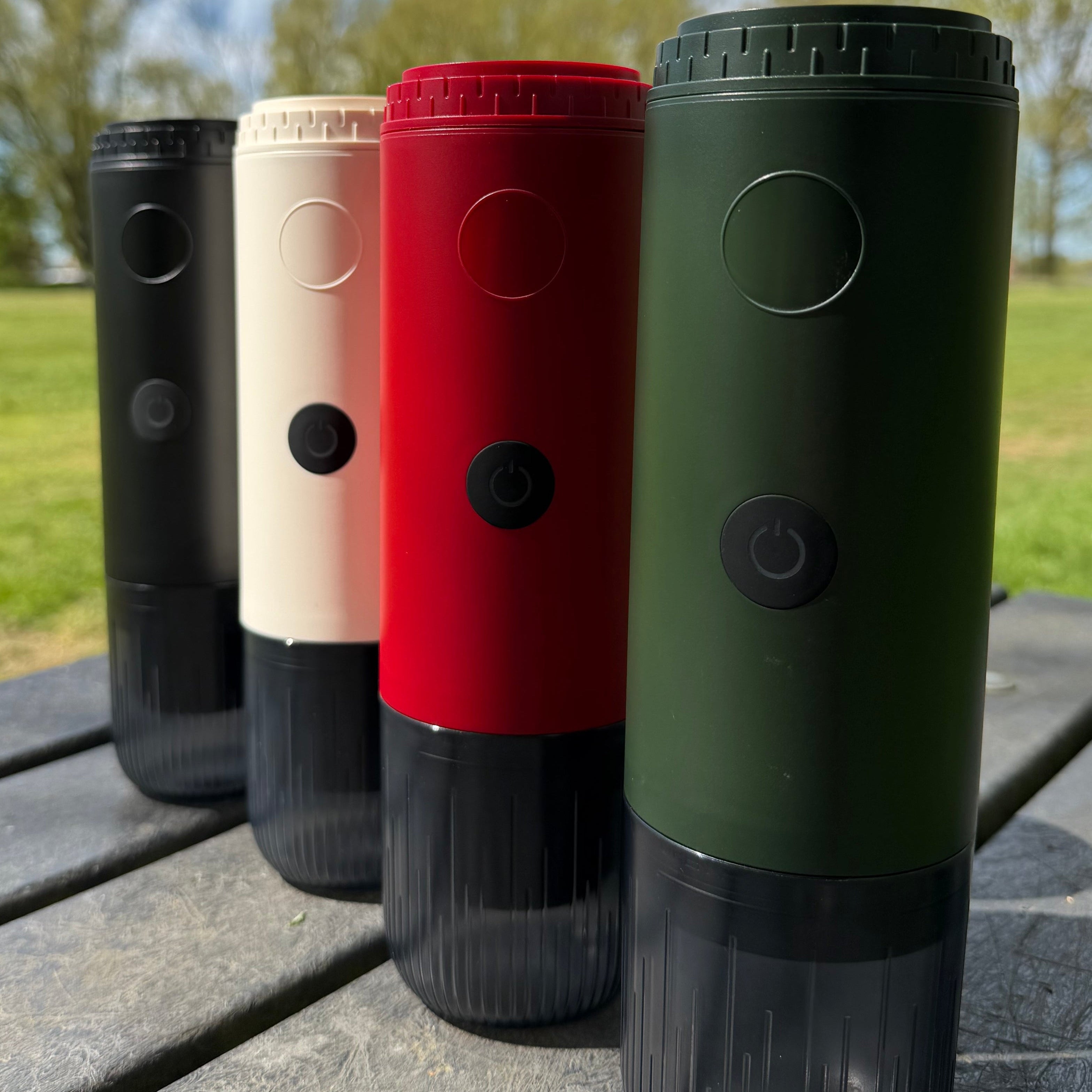four different colour portable espresso machines, green, red, white and black.