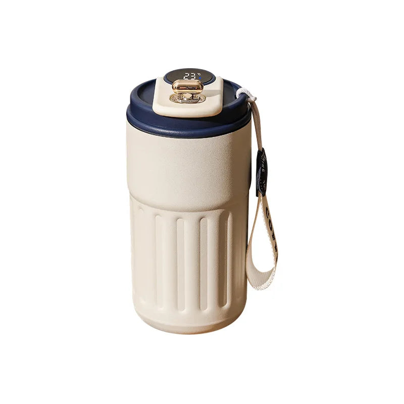 Beige insulated coffee travel mug with blue lid and carrying strap on white background