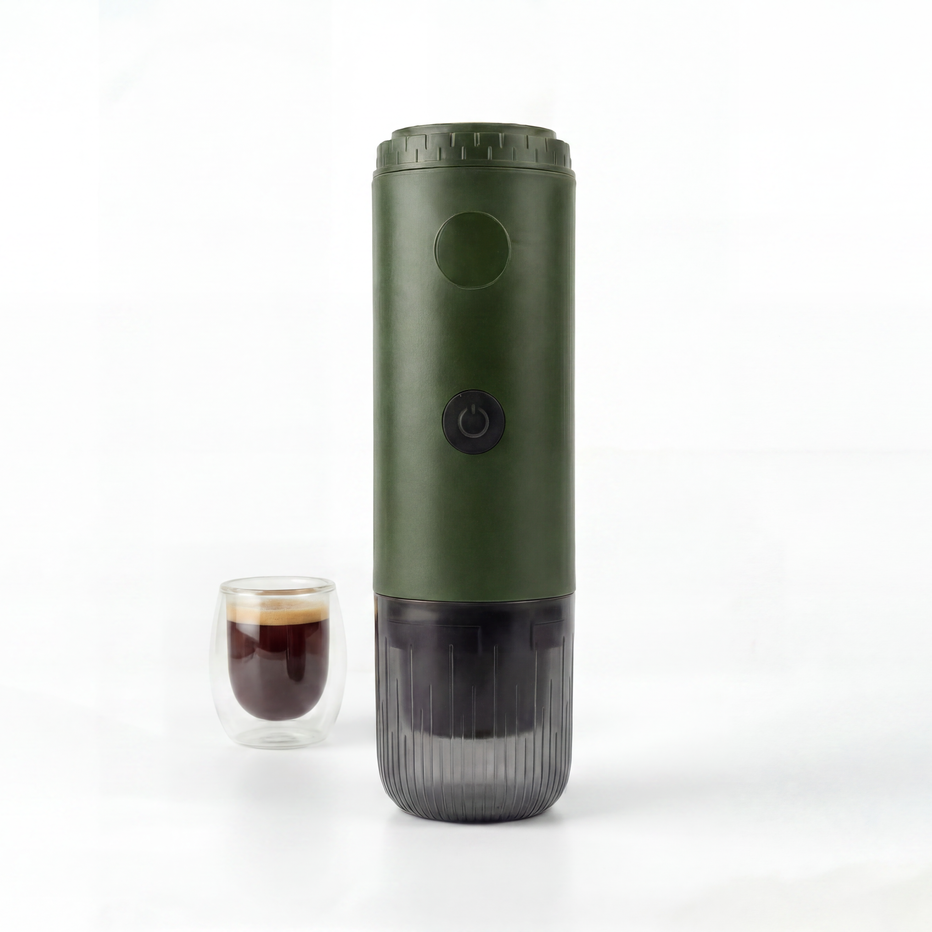 Green portable espresso maker next to a glass of coffee on a white background