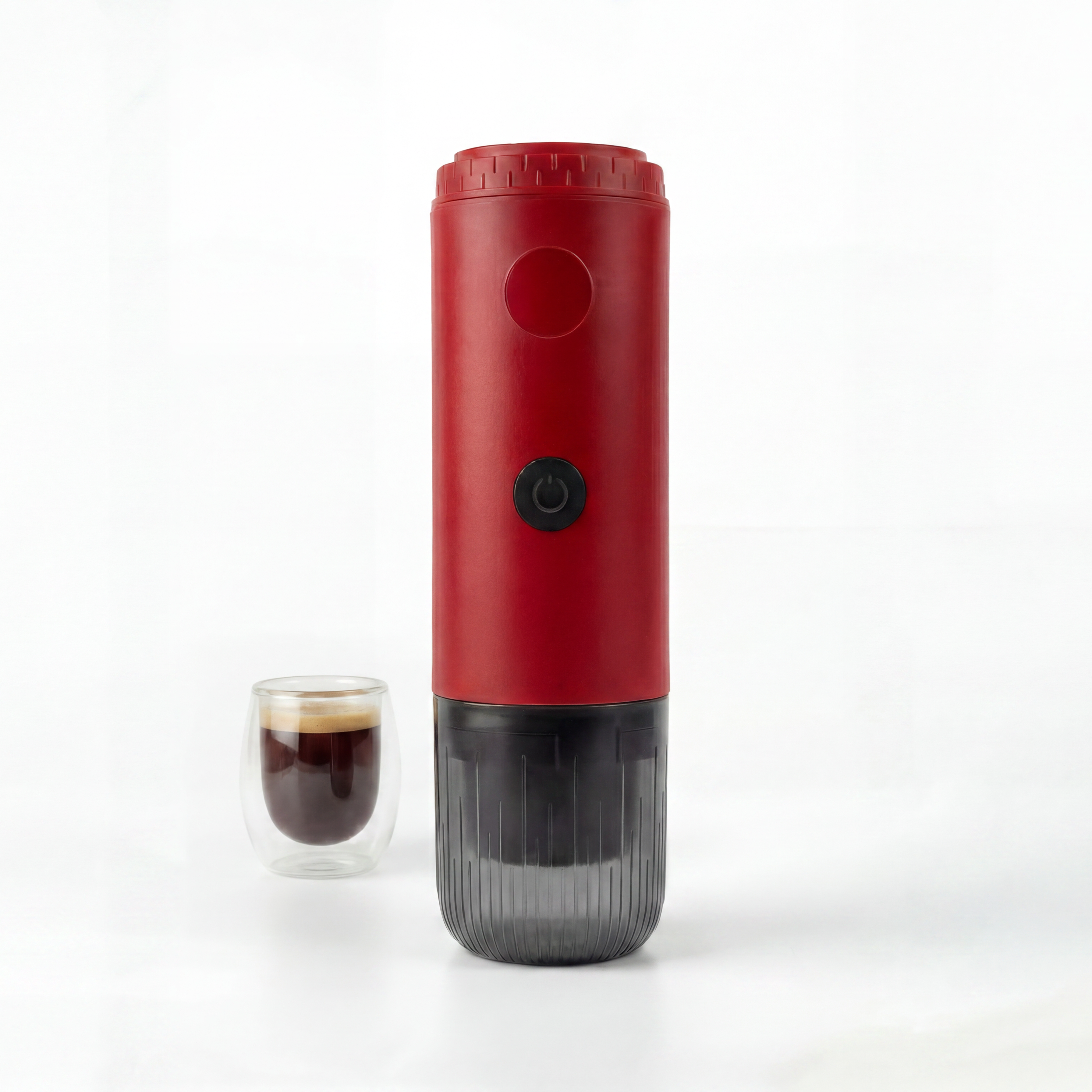 Red portable espresso maker next to a glass of coffee on a white background